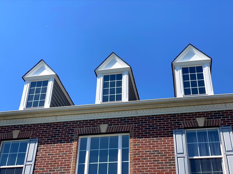 Dormers, trim and shutters repainted on a brick colonial