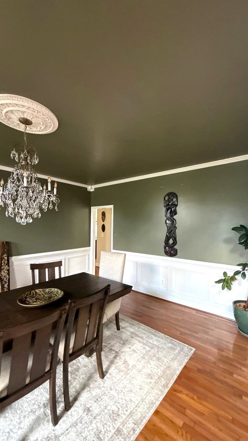Formal dining room by ARM Premium Painting — Deep wall color above a crisp white chair rail