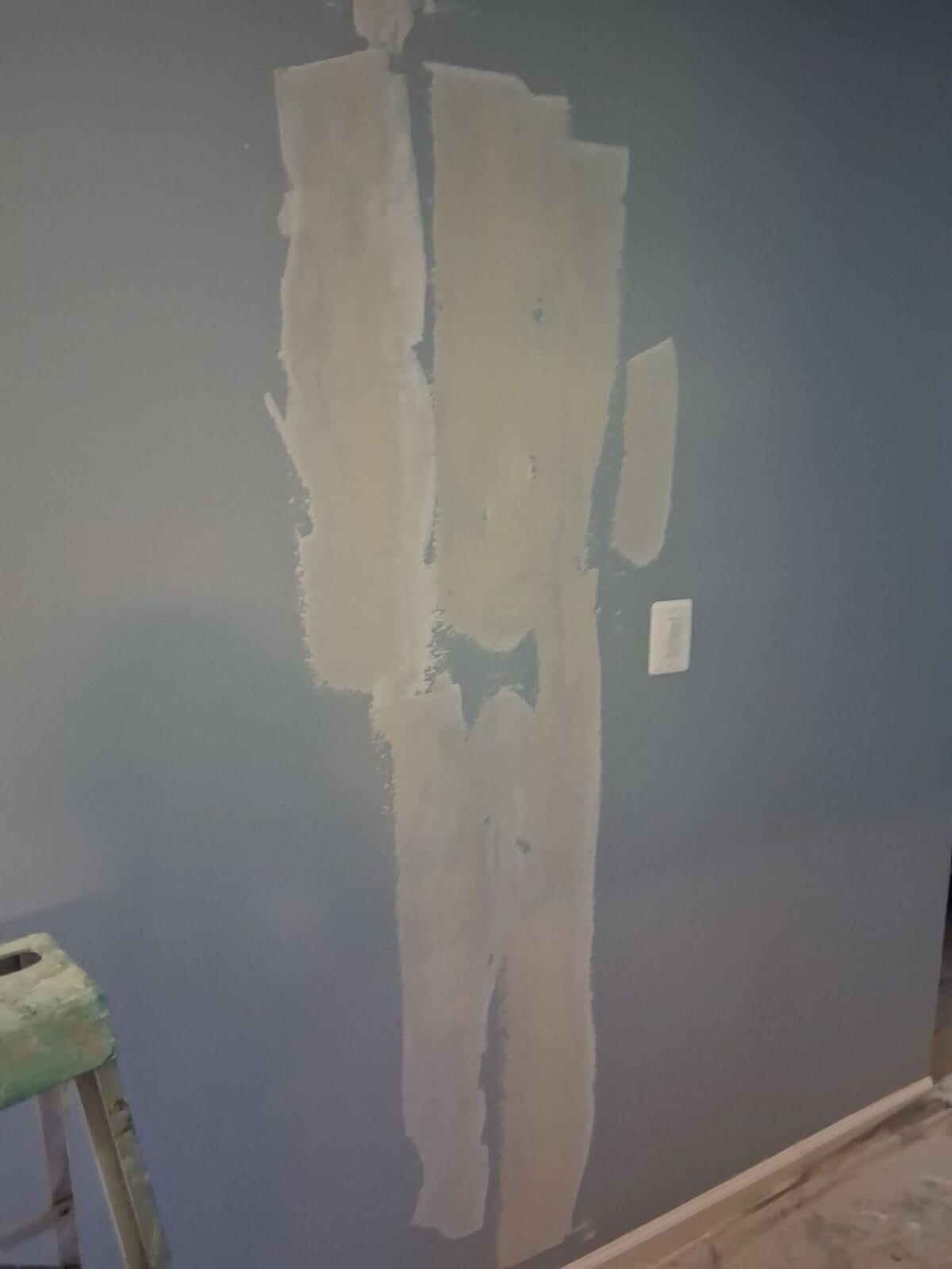 Joint compound drying over drywall repairs on an interior wall