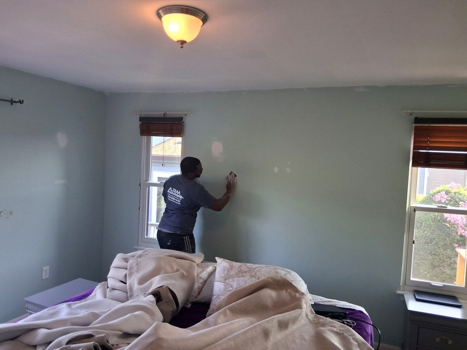 ARM Premium Painting crew member cutting in an interior wall by hand