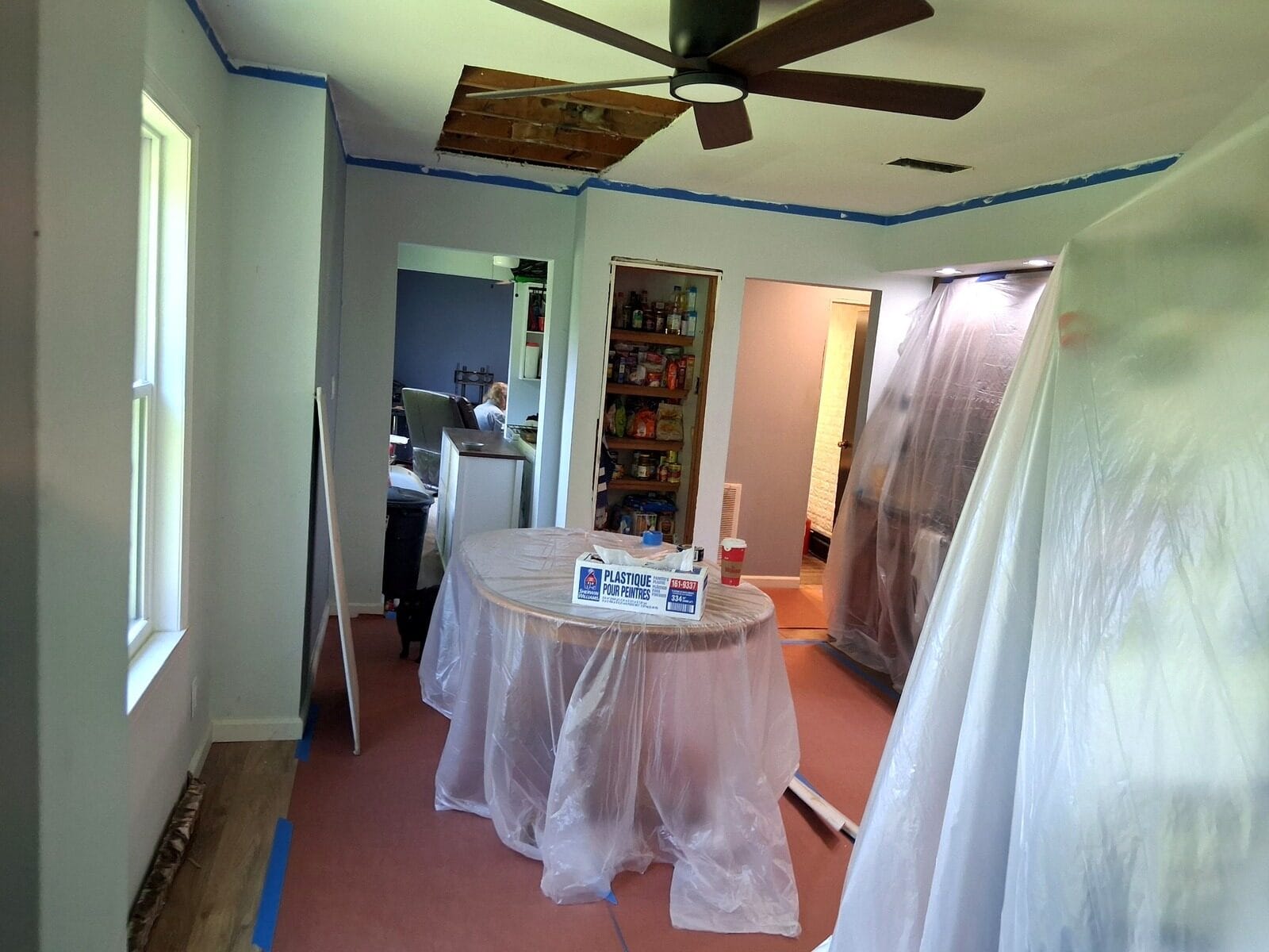 Furniture and floors protected with plastic sheeting before painting