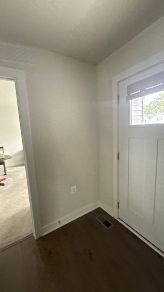 Entry hallway repainted in a light neutral with crisp white doors and trim