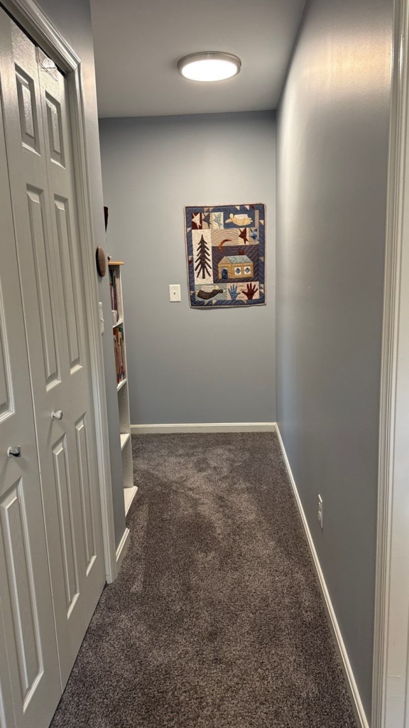 Upstairs hallway painted in a calm blue-gray with white doors